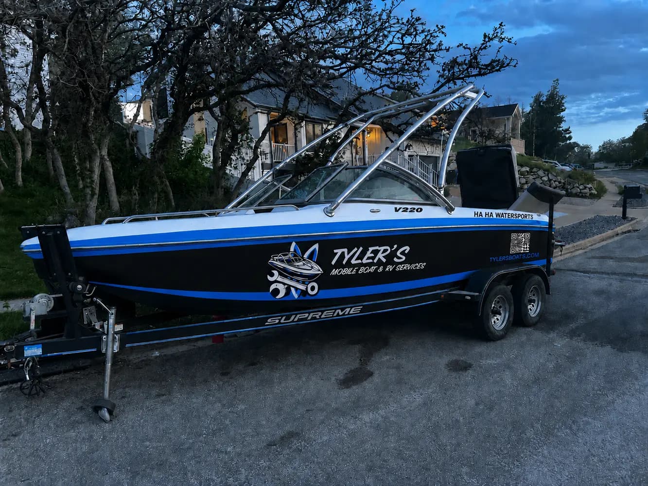 Branded Tyler's Mobile Boat and RV Service Supreme wake boat on its trailer