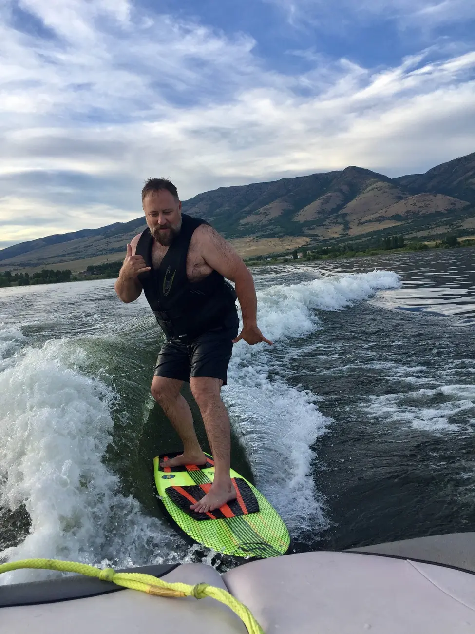Jeff wakesurfing behind a boat on a Utah lake