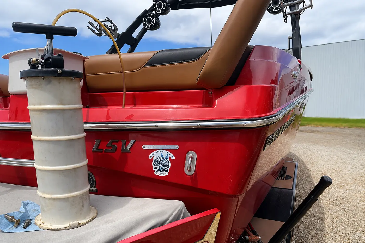Fluid extraction equipment in use during preventive maintenance on a red wake boat